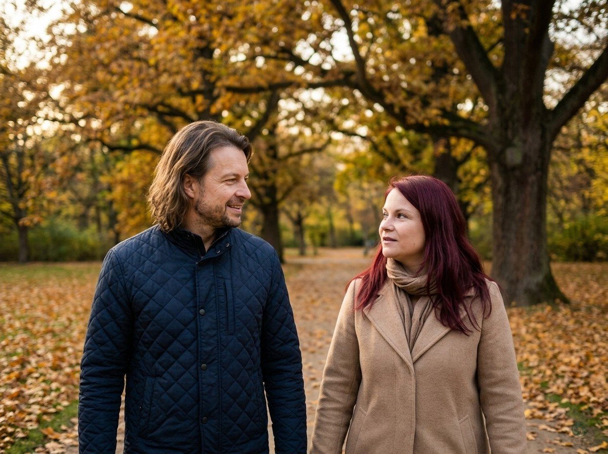 KI-generiert: Maik Marx und Nicole gehen in einem Berliner Park spazieren, Herbstlaub, sie in einem beigen Mantel, er in einer dunkelblauen Jacke, ruhiges Gespräch